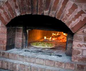 wood fired oven with pizza cooking inside