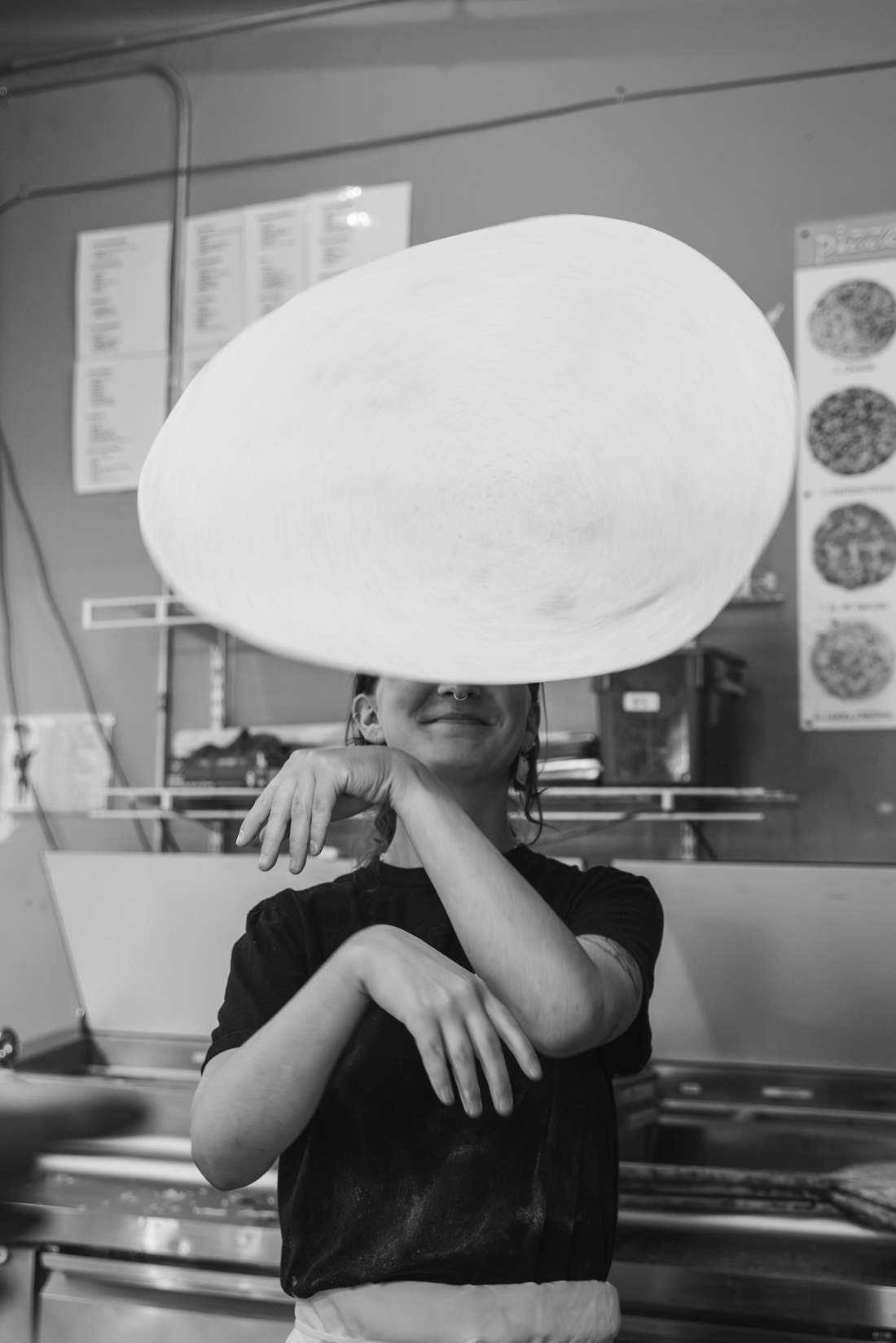 Folino's employee tossing a pizza