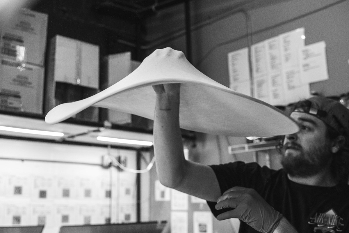 pizza dough being spun in the air