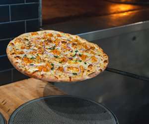 Buffalo Cauliflower pizza coming out of the oven.