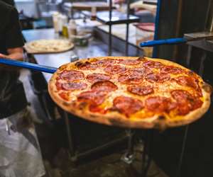 Pepperoni pizza coming out of the oven