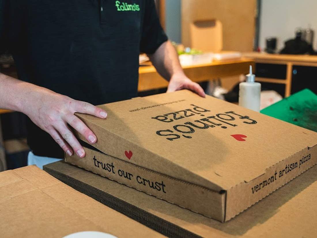 Folinos employee enclosing a pizza in a box