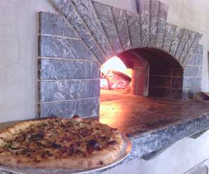 a finished pizza on woodfired oven shelf after cooking